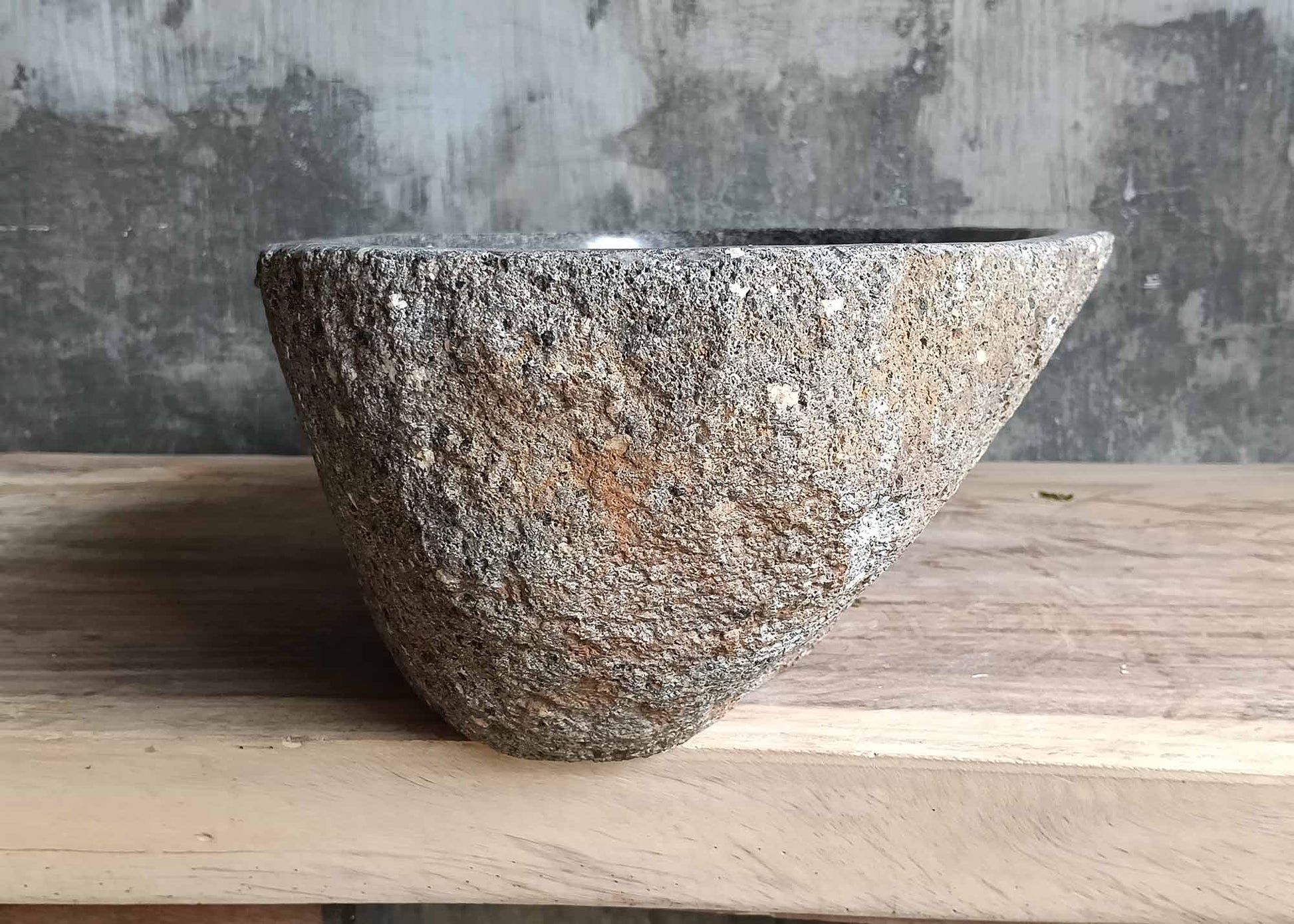 Left side view of oval river stone sink SKU 6083-5335 with natural uneven stone exterior and polished interior finish
