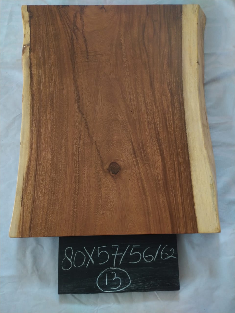Top view of suar wood slab 0013-575662 with live edge shape and natural brown wood grain, solid single-piece countertop.
