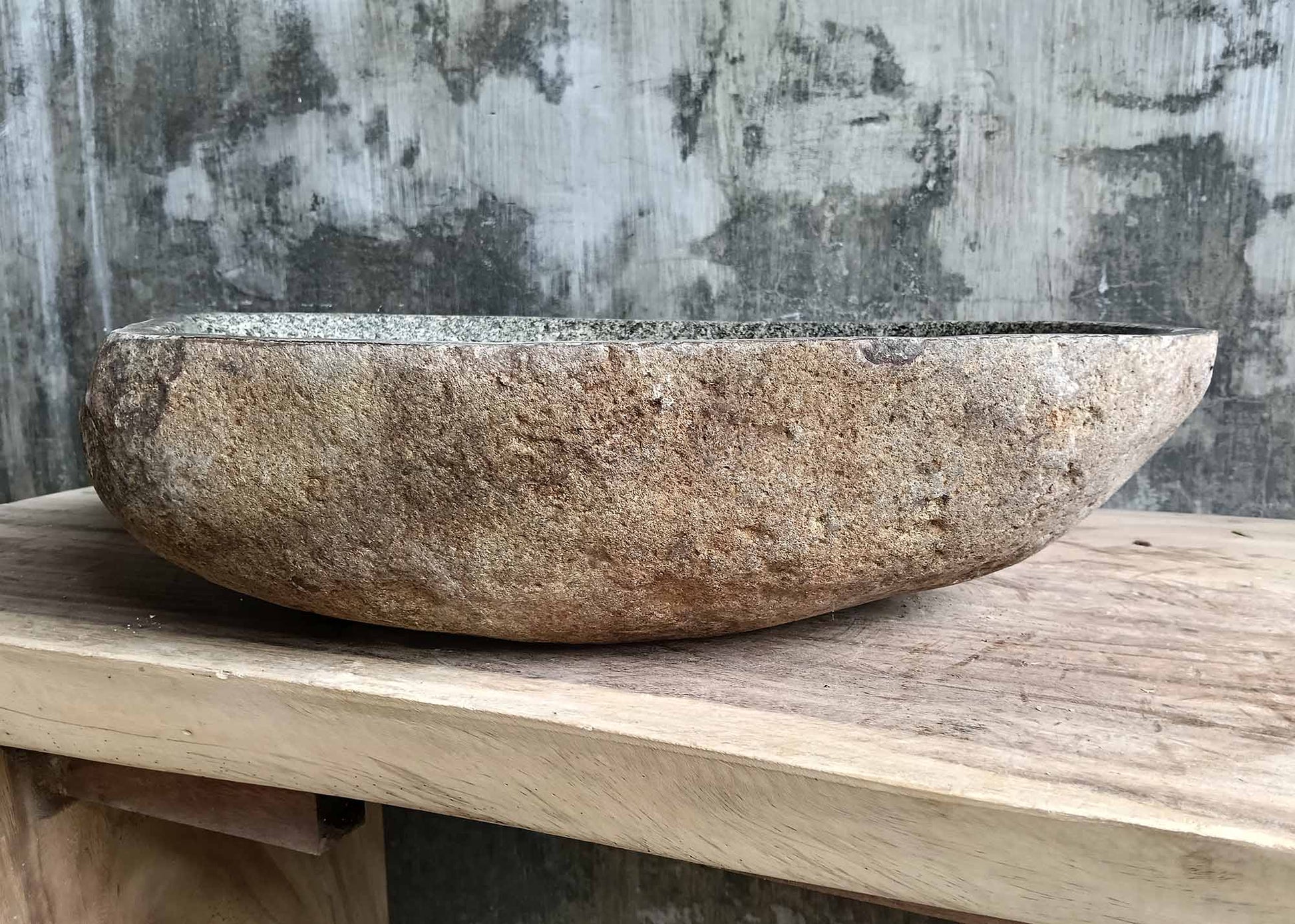 Rear view of river stone sink highlighting the textured rough outer shell and natural stone color variations

