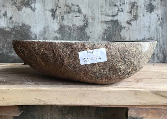 Front view of handcrafted river stone sink showing rough natural stone exterior and smooth polished interior
