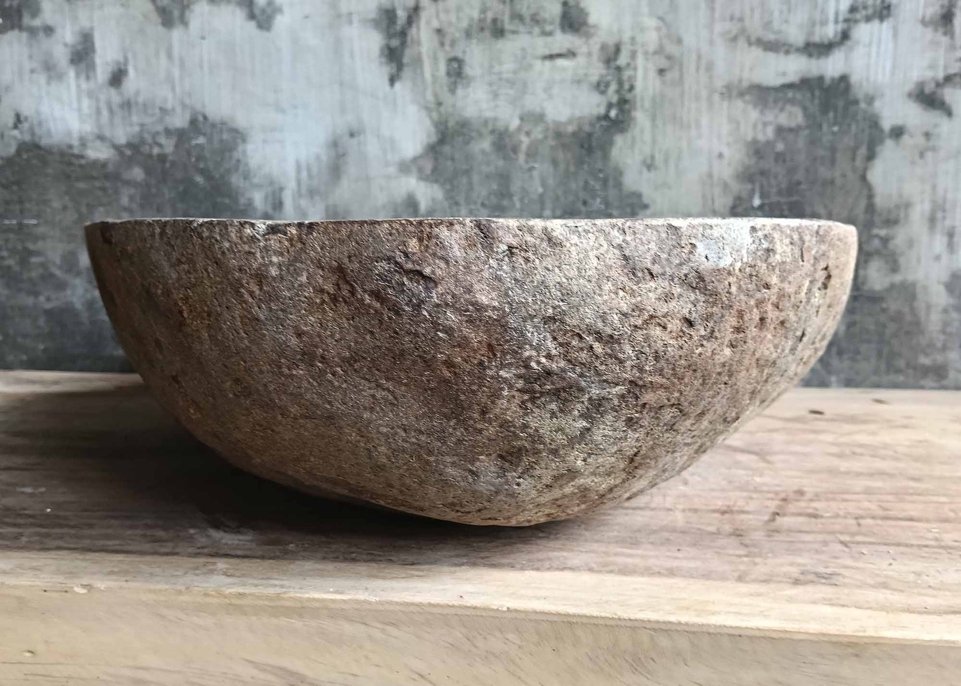 Left side view of river stone sink featuring natural irregular shape and rugged stone texture
