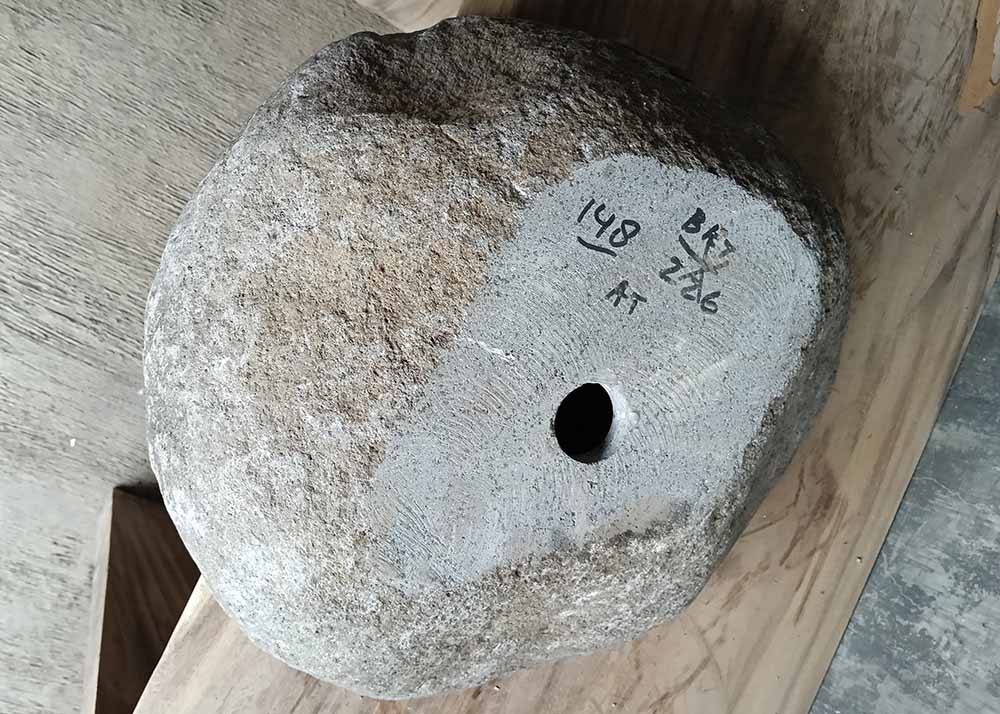 Bottom view of river stone sink SKU 6148-5247 with rough stone underside and product label visible

