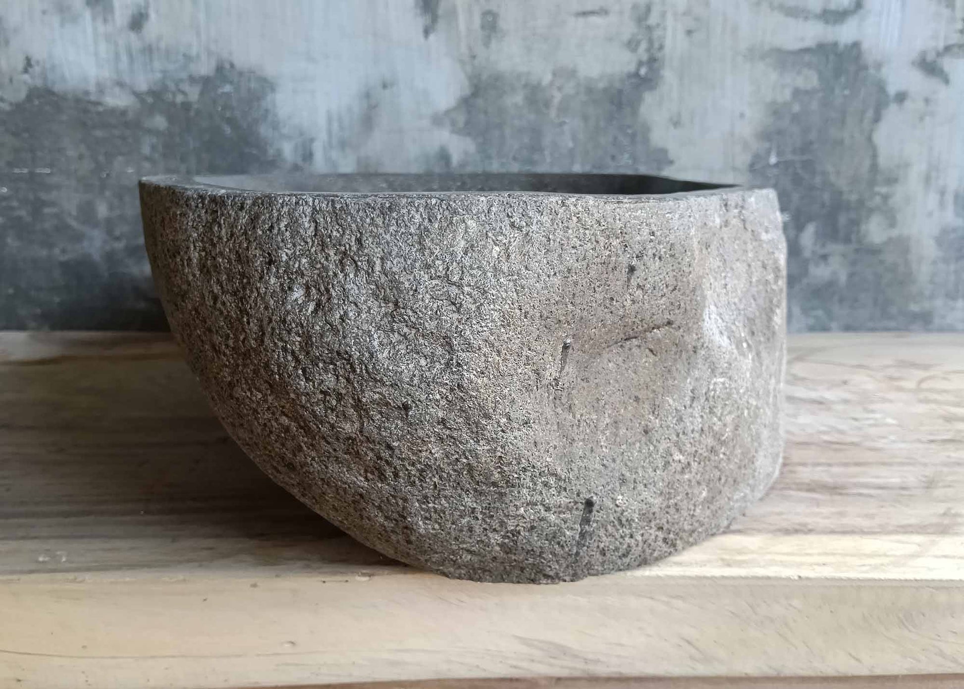 Left side of river stone sink SKU 6150-5837 with raw exterior and deep polished inner bowl
