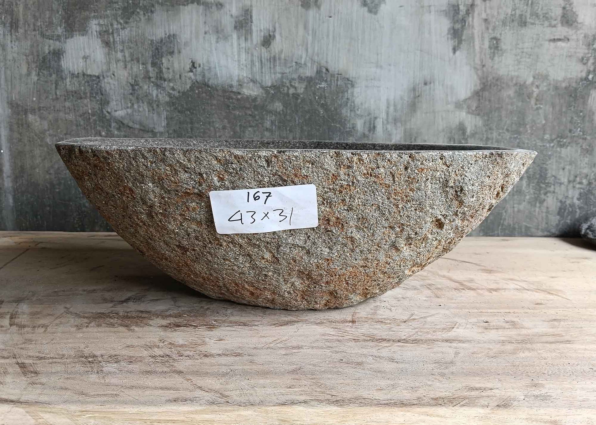 Back view of 17×12 inch oval gray river stone sink with natural stone surface
