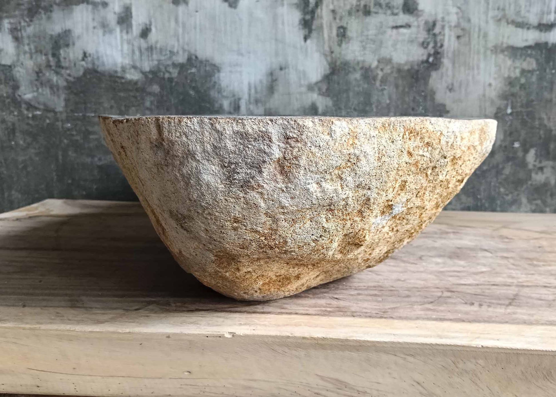 Left side of river stone sink SKU 6170-5437 showing raw golden exterior and deep interior curve
