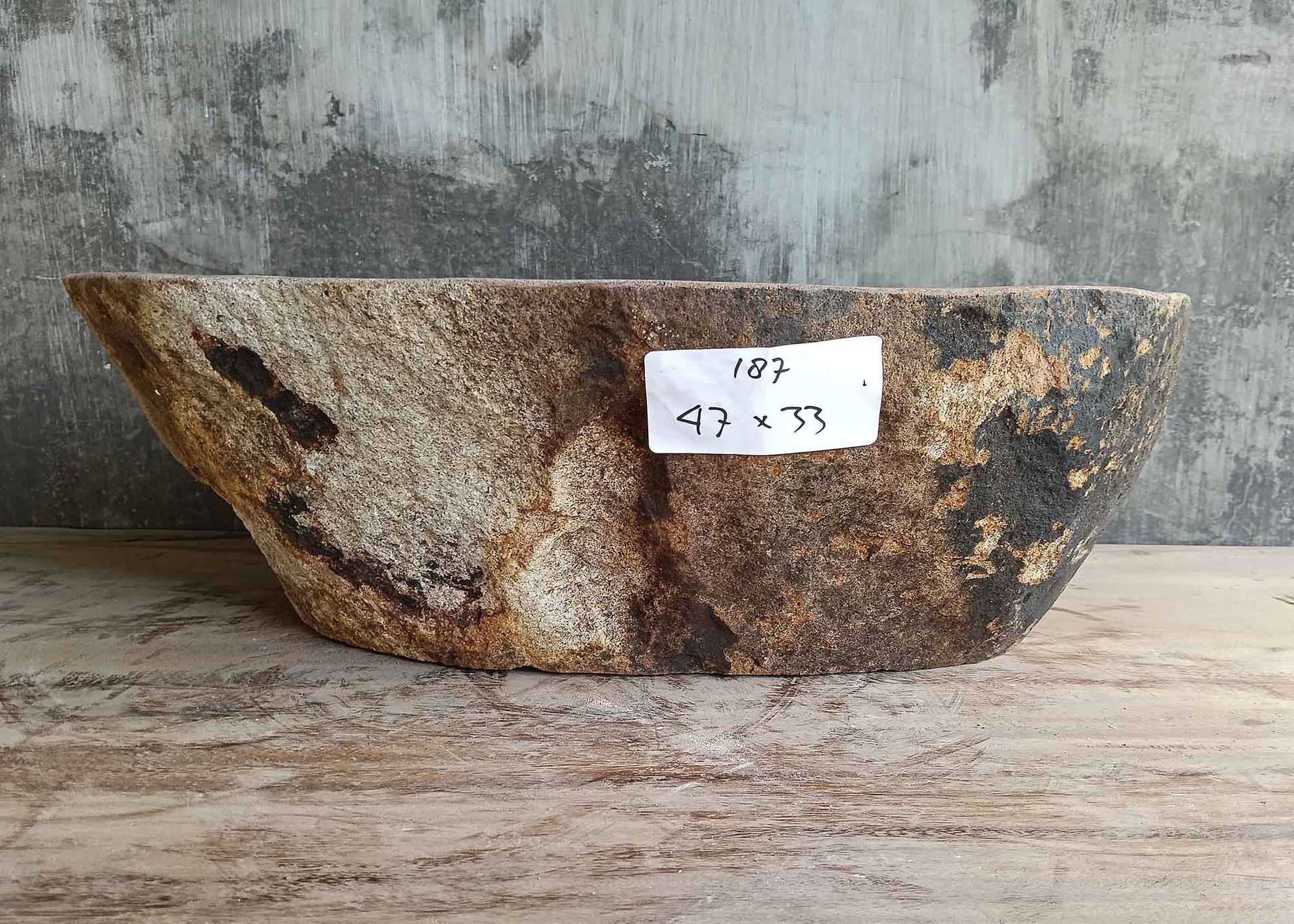 Front side of 18×13 inch river stone sink showing reddish natural exterior and curved profile

