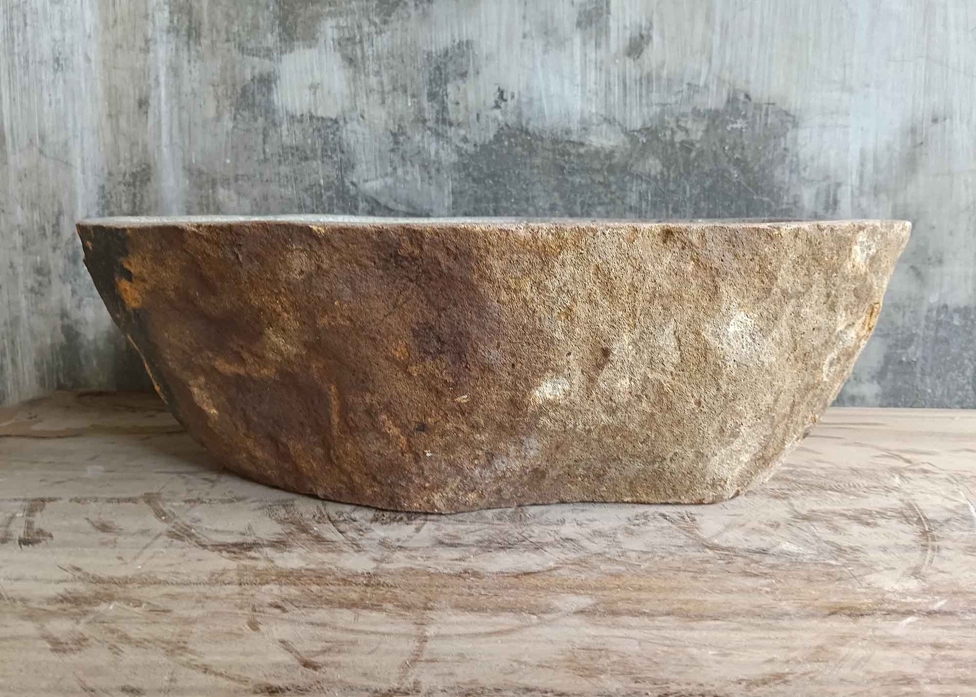 Back view of 18×13 inch oval river stone sink with light gray top and warm-toned stone base
