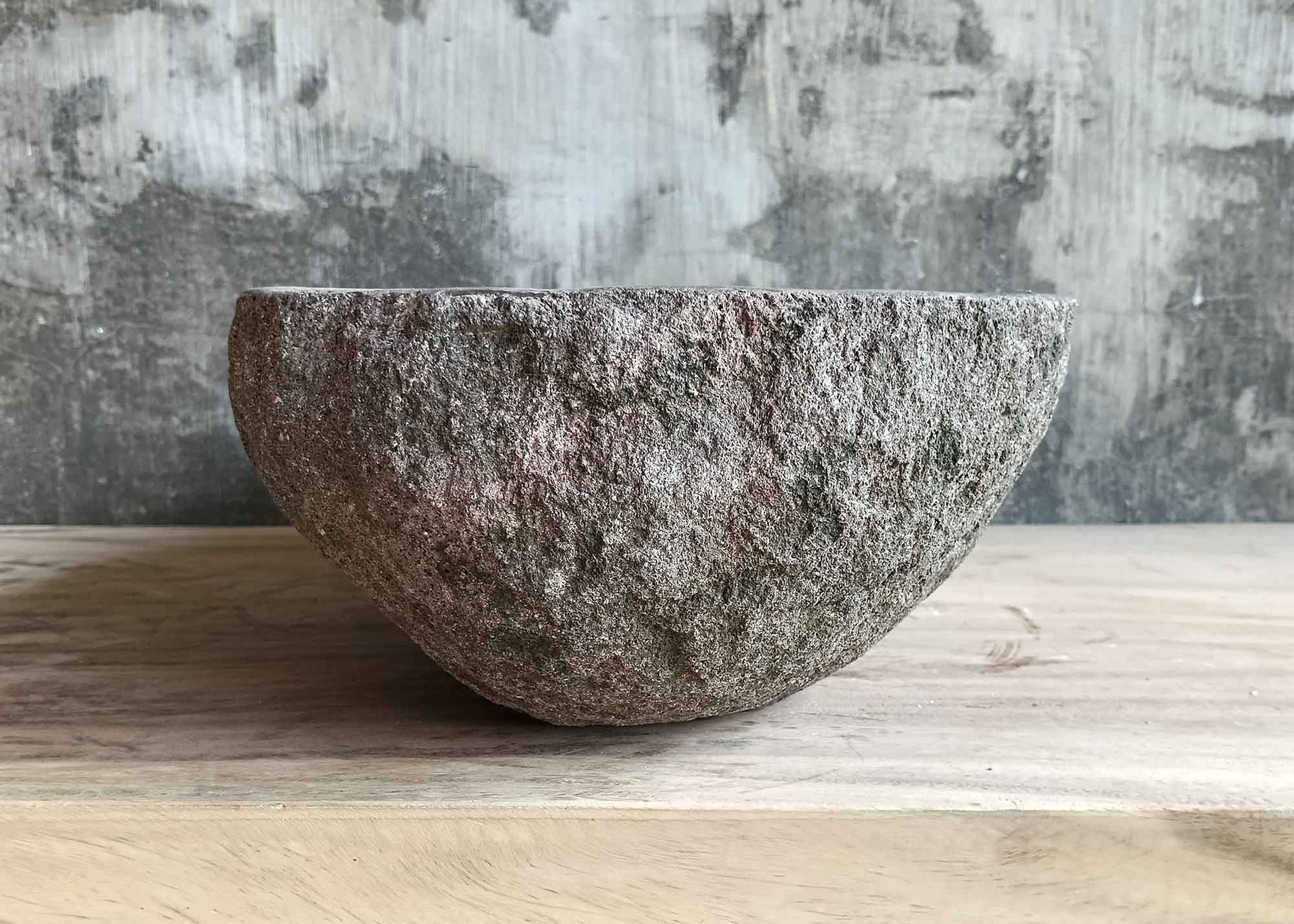 Right side of handcrafted brown 18×12 inch stone sink with oval lines and organic finish
