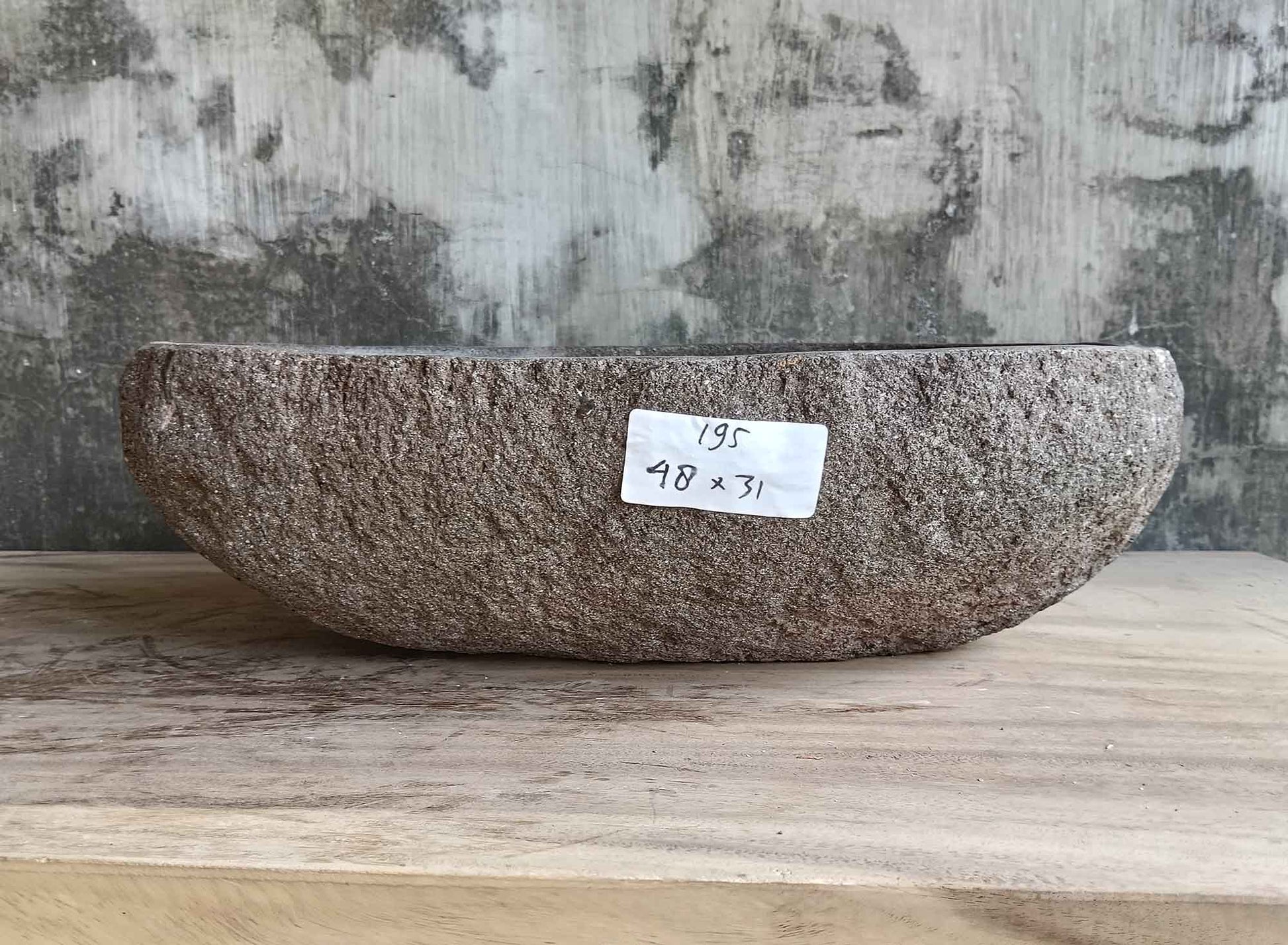 Back side of brown 18×12 inch stone sink showing raw textured surface and curved form
