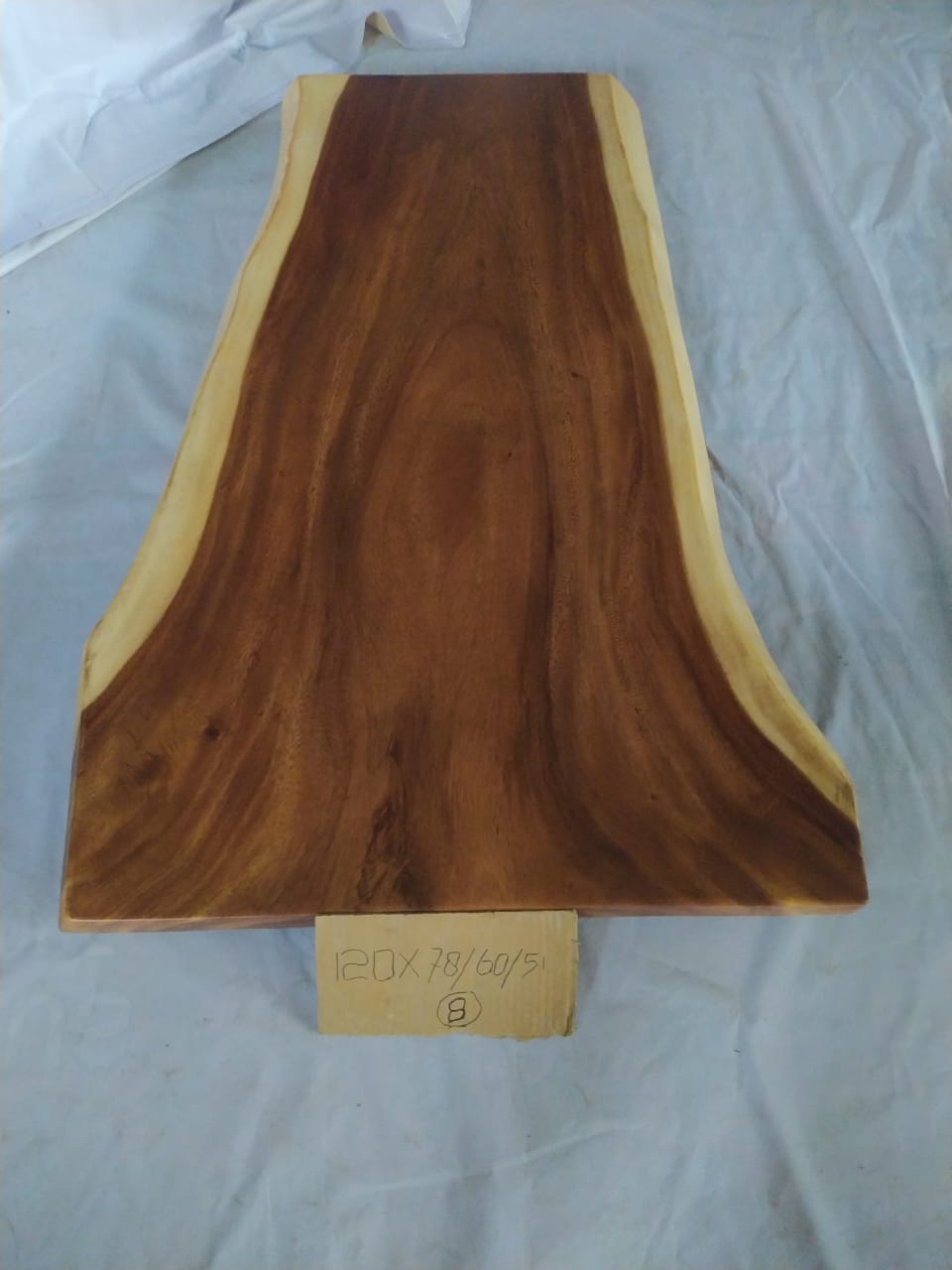 Top view of suar wood slab 0001-786051 with long tapered live edge shape and rich brown natural wood grain, solid single-piece countertop.
