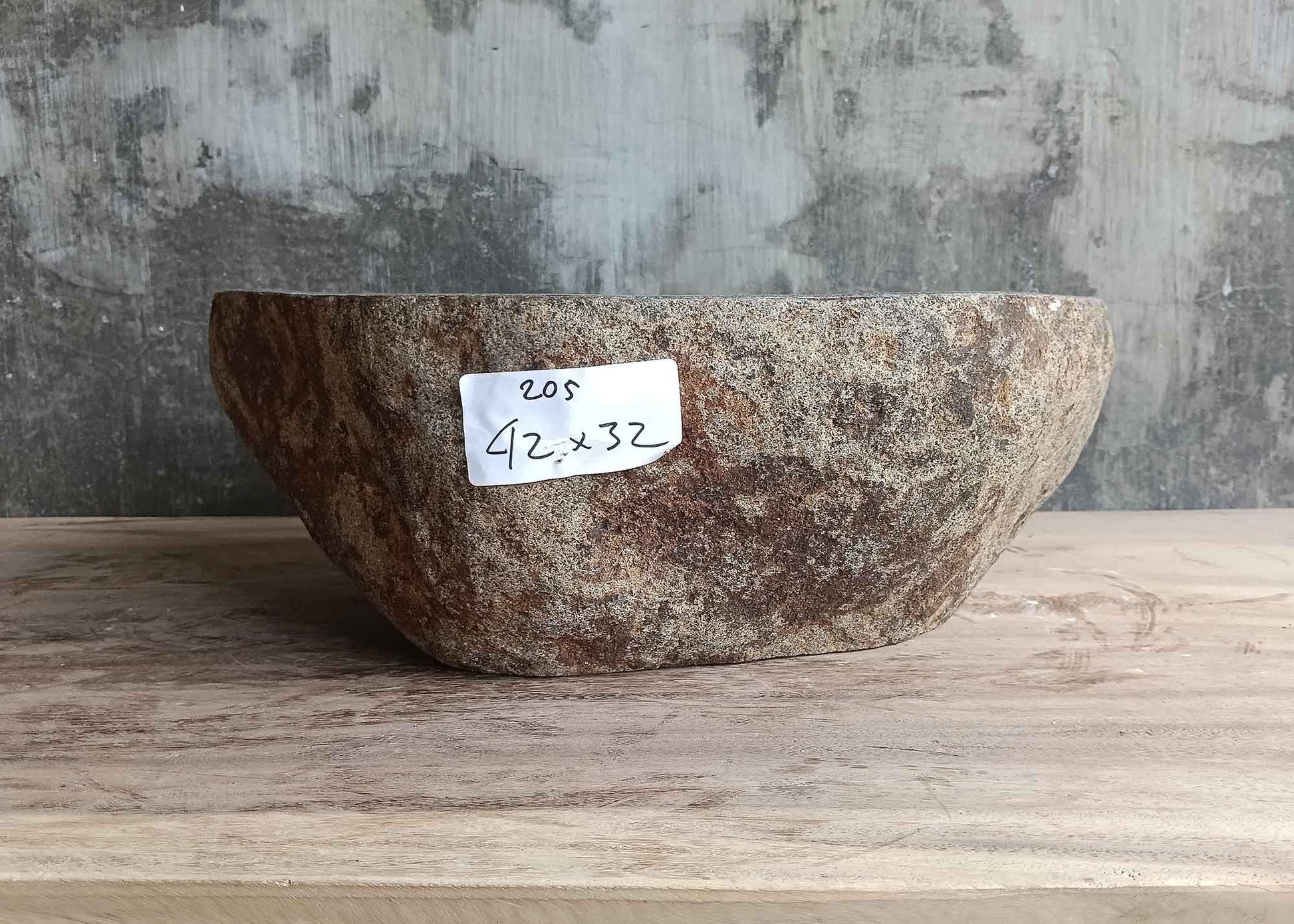 Back side of handcrafted 16×13 inch gray stone sink with natural oval curve
