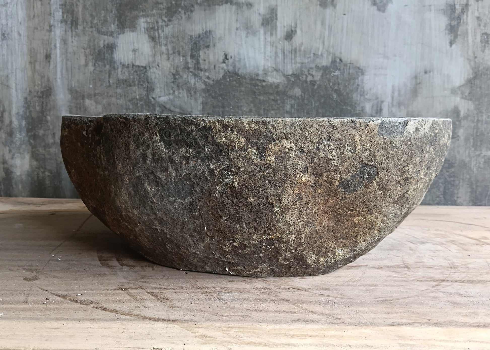 Back view of 16×12 river stone sink with raw exterior and deep gray tone
