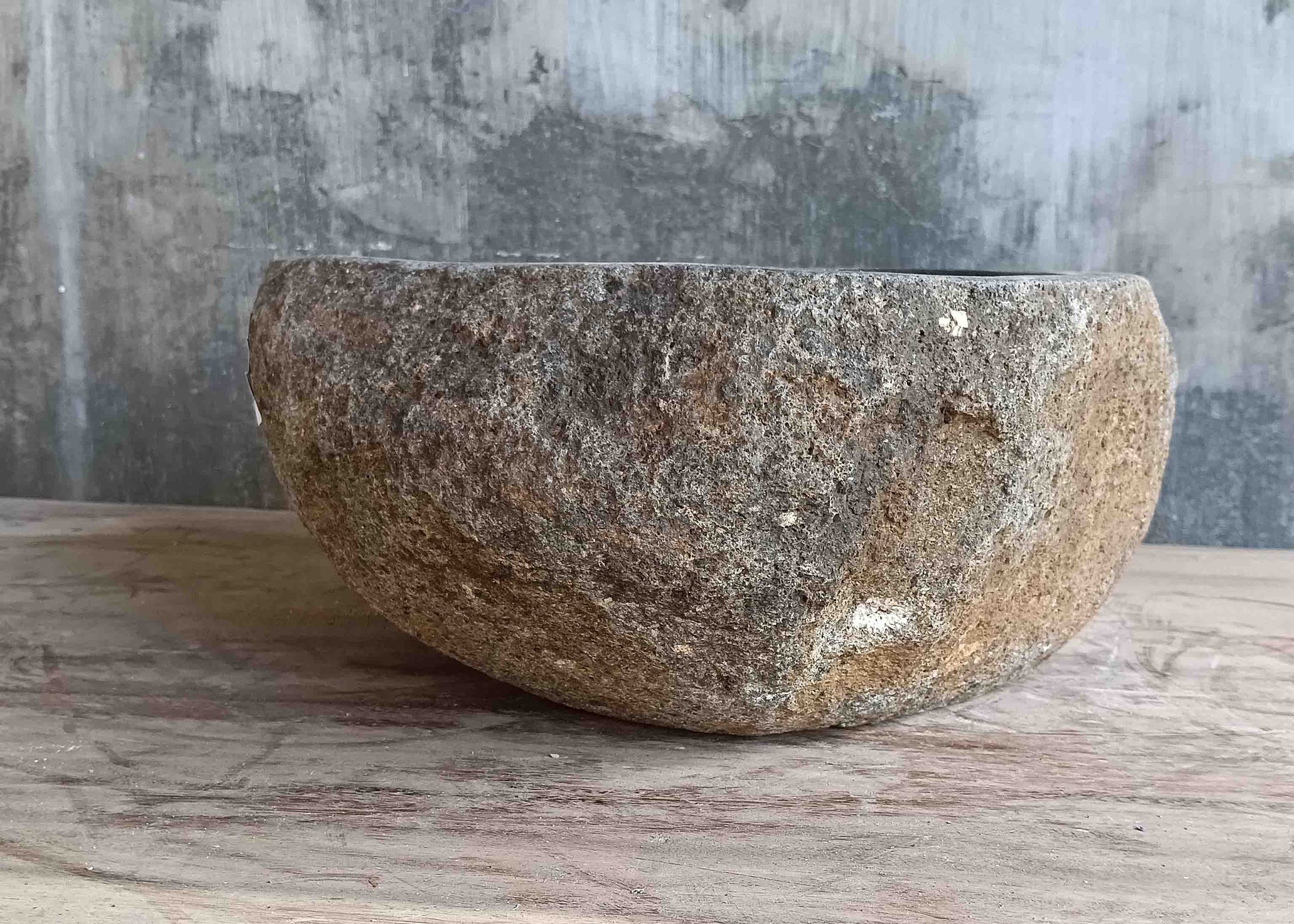 Left side view of 13×13 inch grey-brown river stone sink installed in countertop
