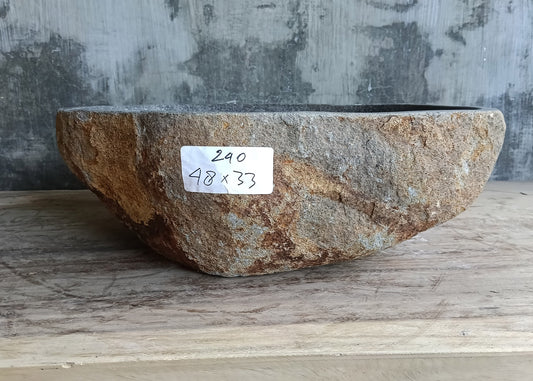 Front view of asymmetrical gray stone sink showing curved natural edges
