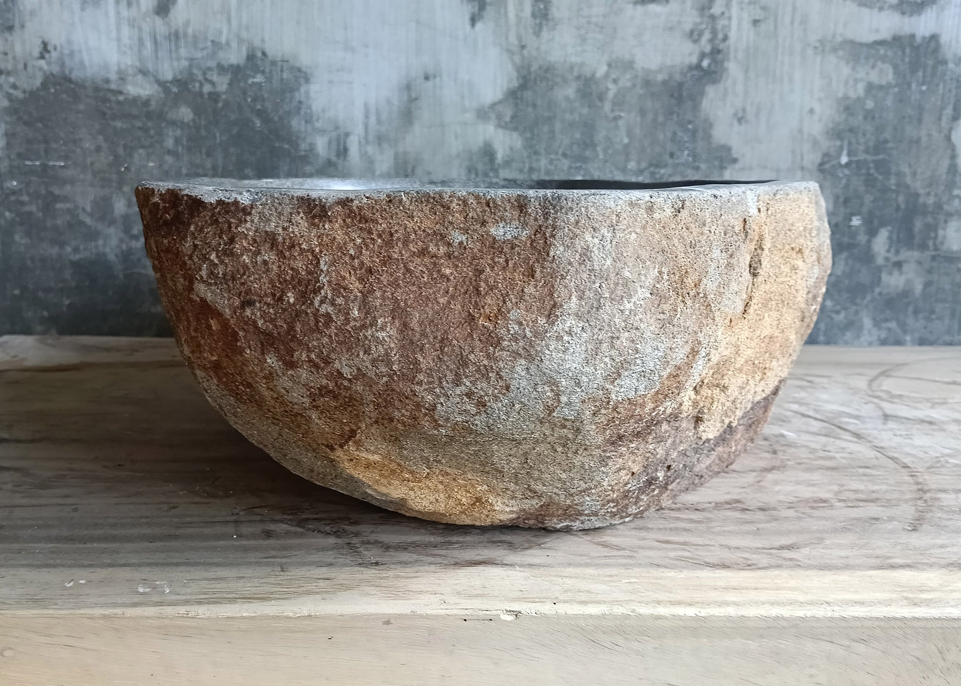 Left side view of gray natural stone sink with unique irregular shape

