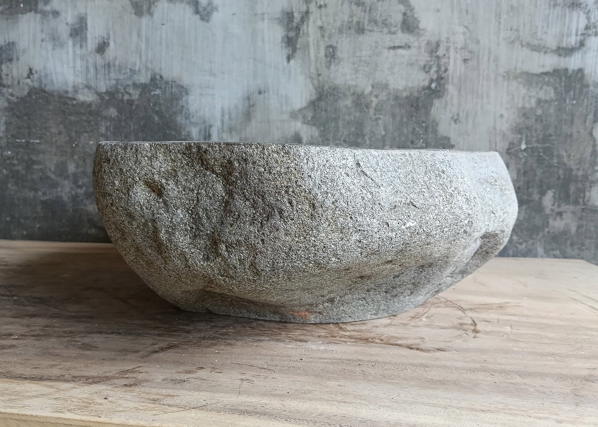 Back view of irregular handcrafted gray river rock sink with polished bowl
