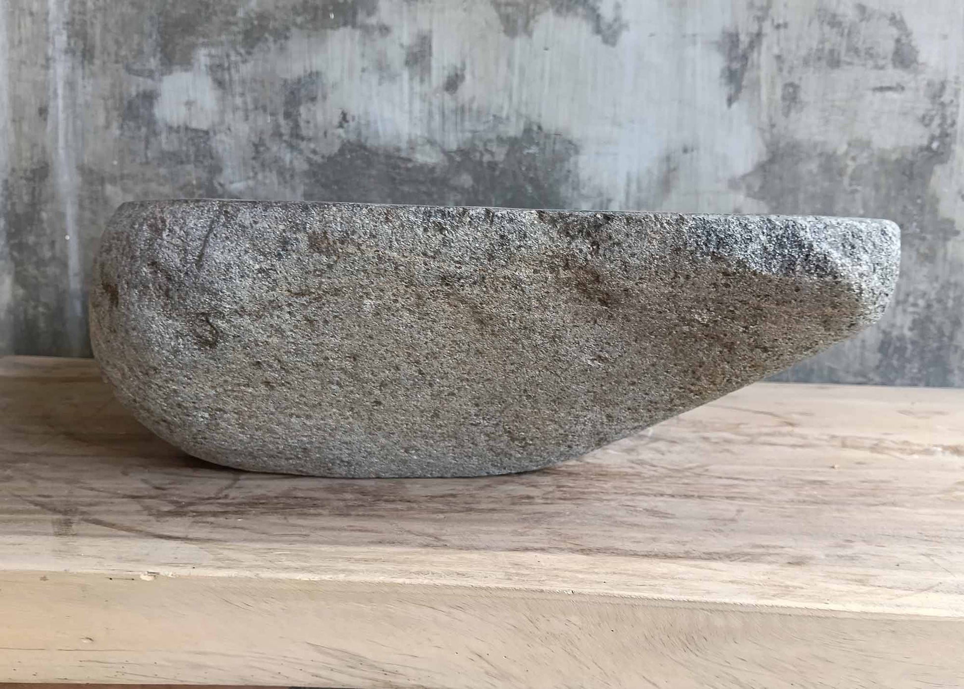 Right profile of river stone sink showing unique form and surface pattern
