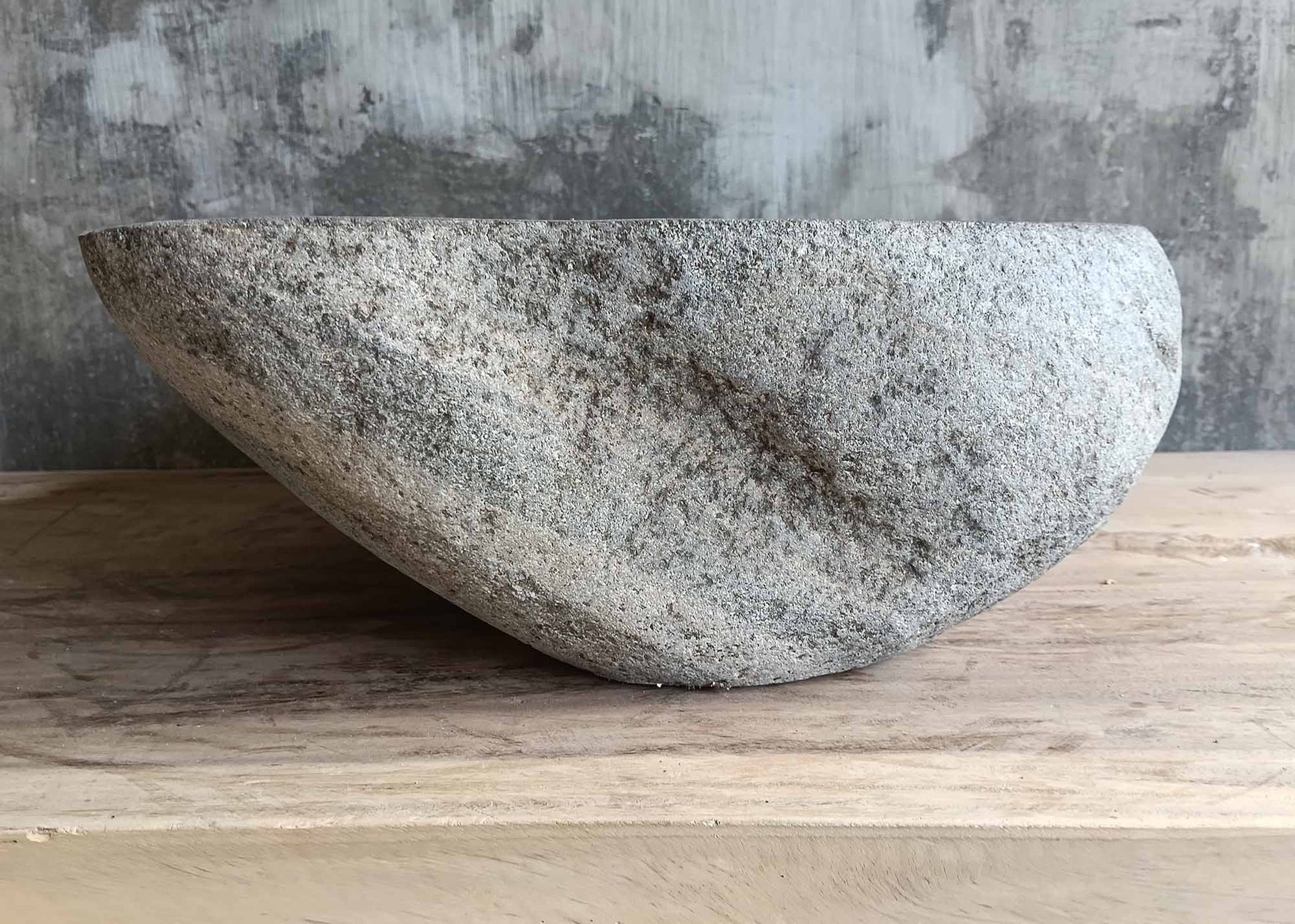 Left side of gray irregular sink with polished bowl and natural veins
