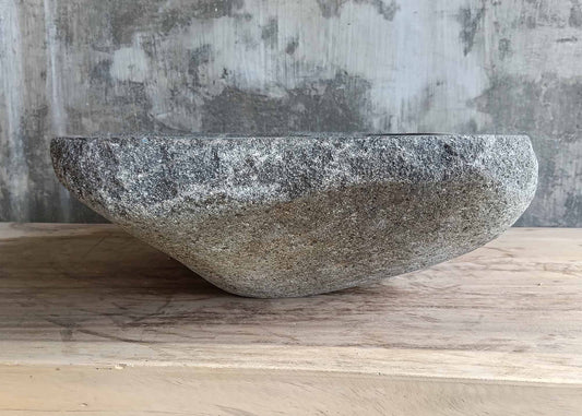 Front angle of handcrafted gray sink with natural boat-shaped profile
