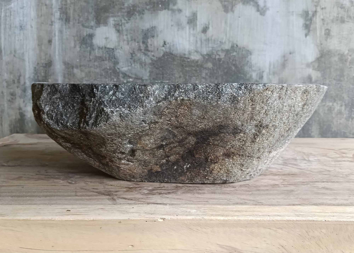 Back view of handcrafted river stone sink with triangular form and stripes
