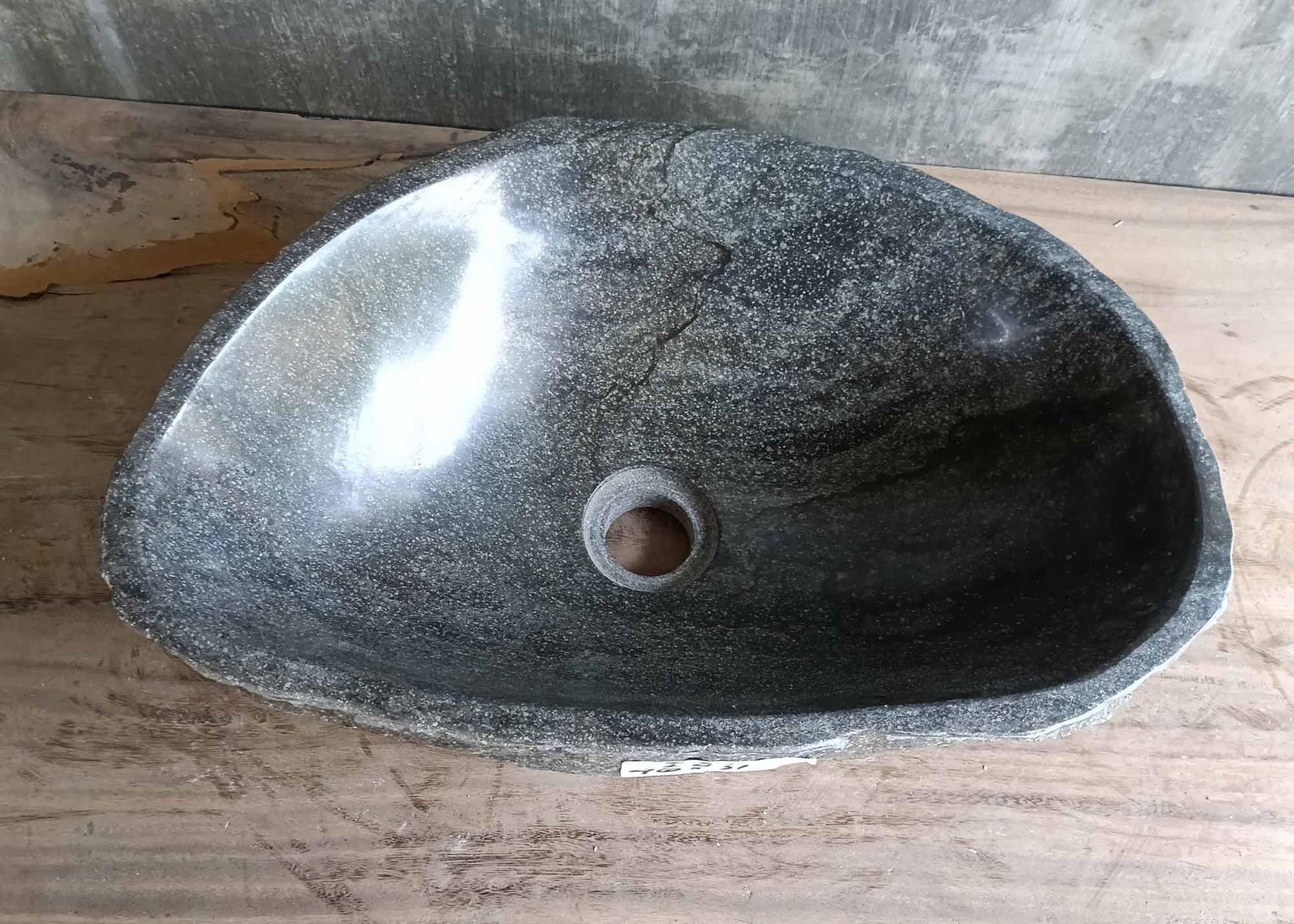 Top view of gray triangular river stone sink with striped polished bowl
