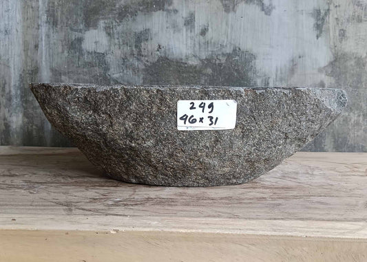 Front angle showing boat-shaped stone sink with rough gray exterior
