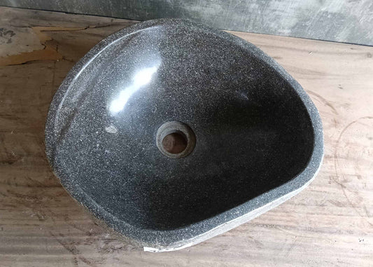 Top view of irregular gray river stone sink with smooth interior
