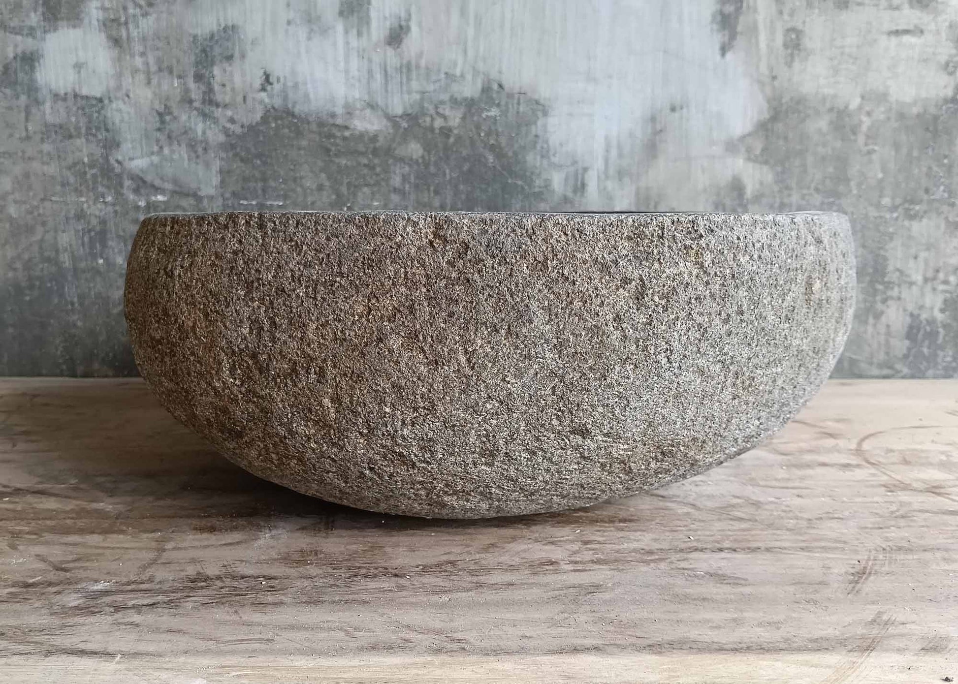Right profile of river stone sink with irregular curves and smooth bowl
