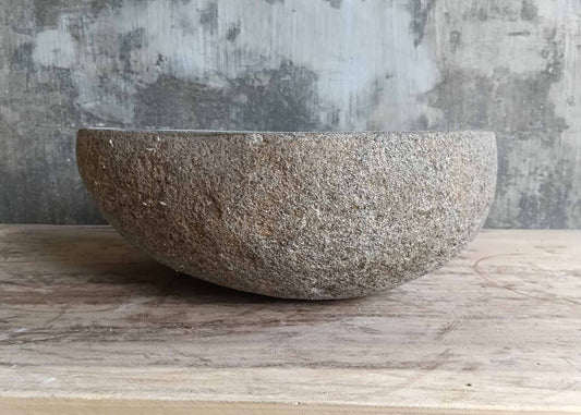 Front view of handcrafted stone sink with natural outer texture
