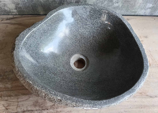 Top view of triangular gray stone sink with polished interior
