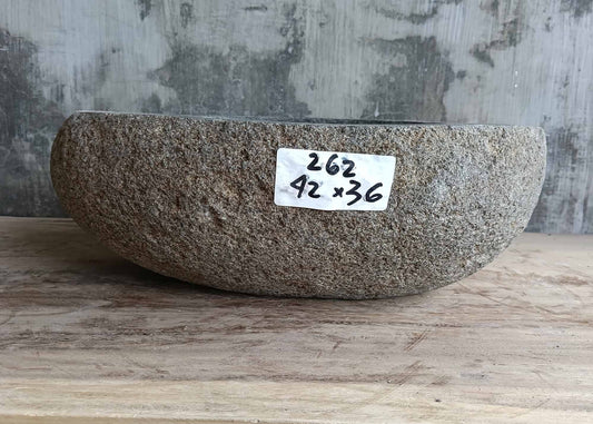 Front side of gray river stone sink with canoe-style profile
