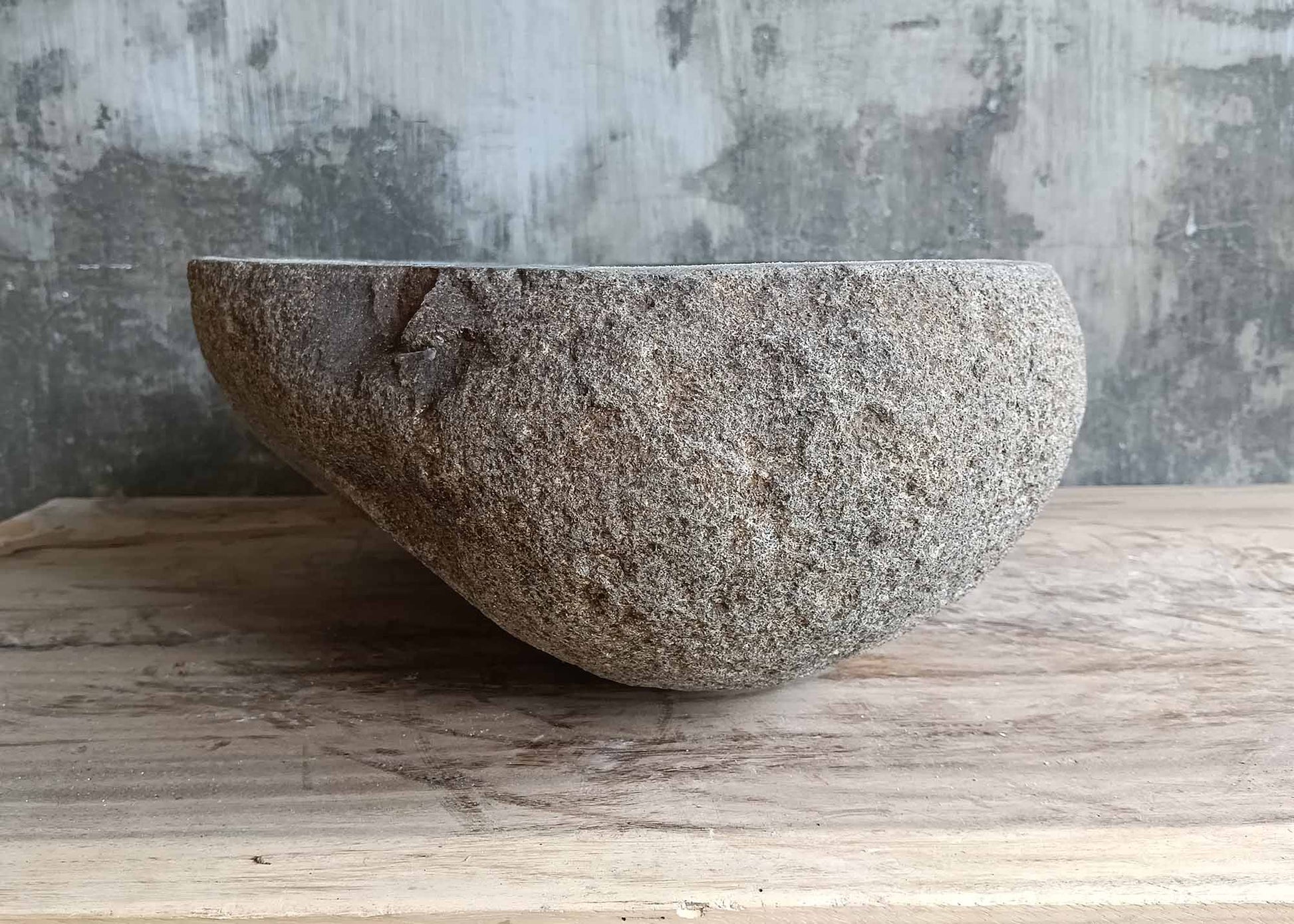 Left side of triangular stone sink showing natural texture
