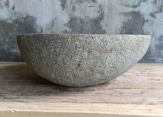 Front angle of handcrafted gray stone sink with canoe profile
