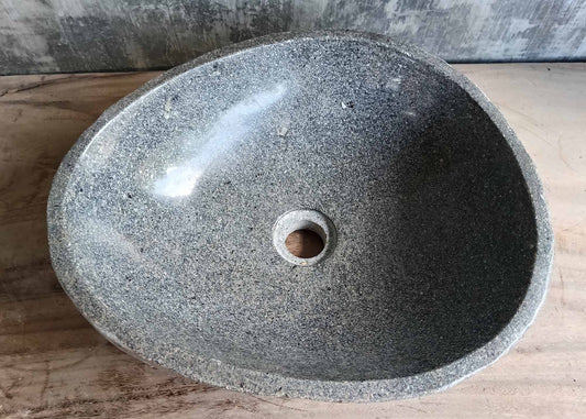 Top view of gray oval stone sink with polished bowl
