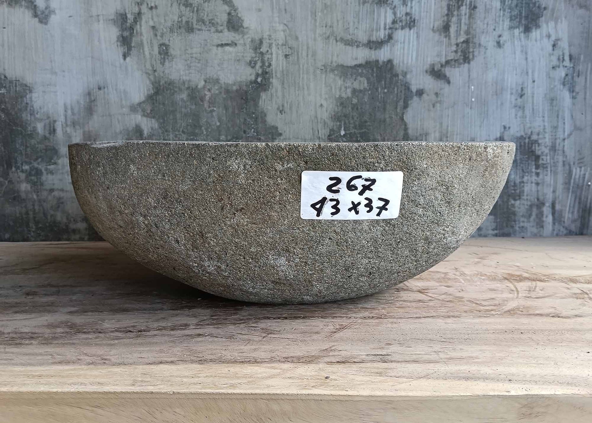Rear view of oval gray stone sink with natural outer texture
