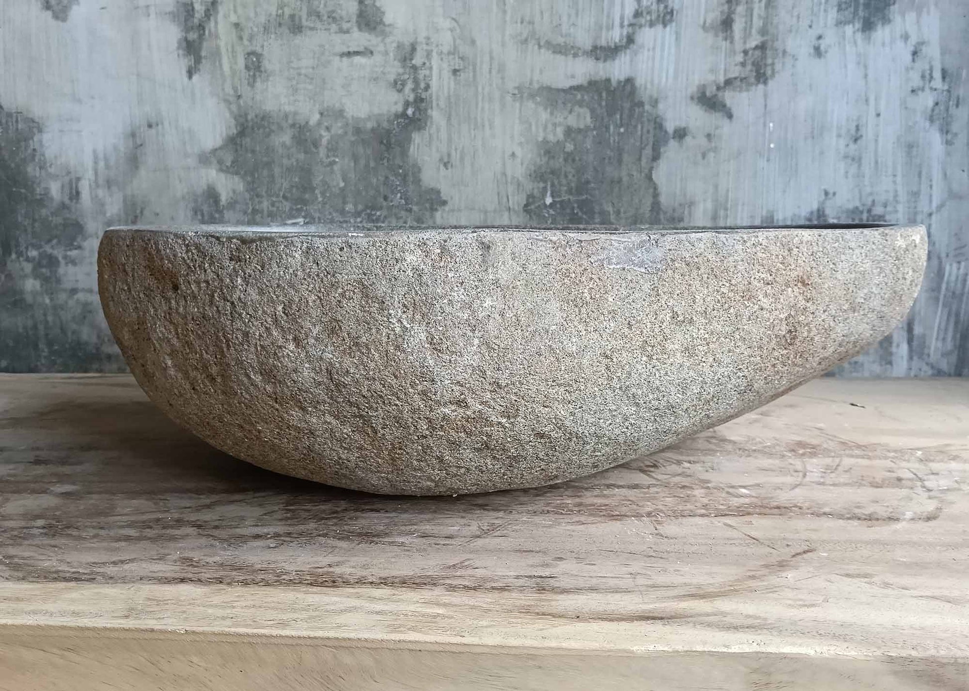 Back view of natural stone sink with tapered pear-like shape
