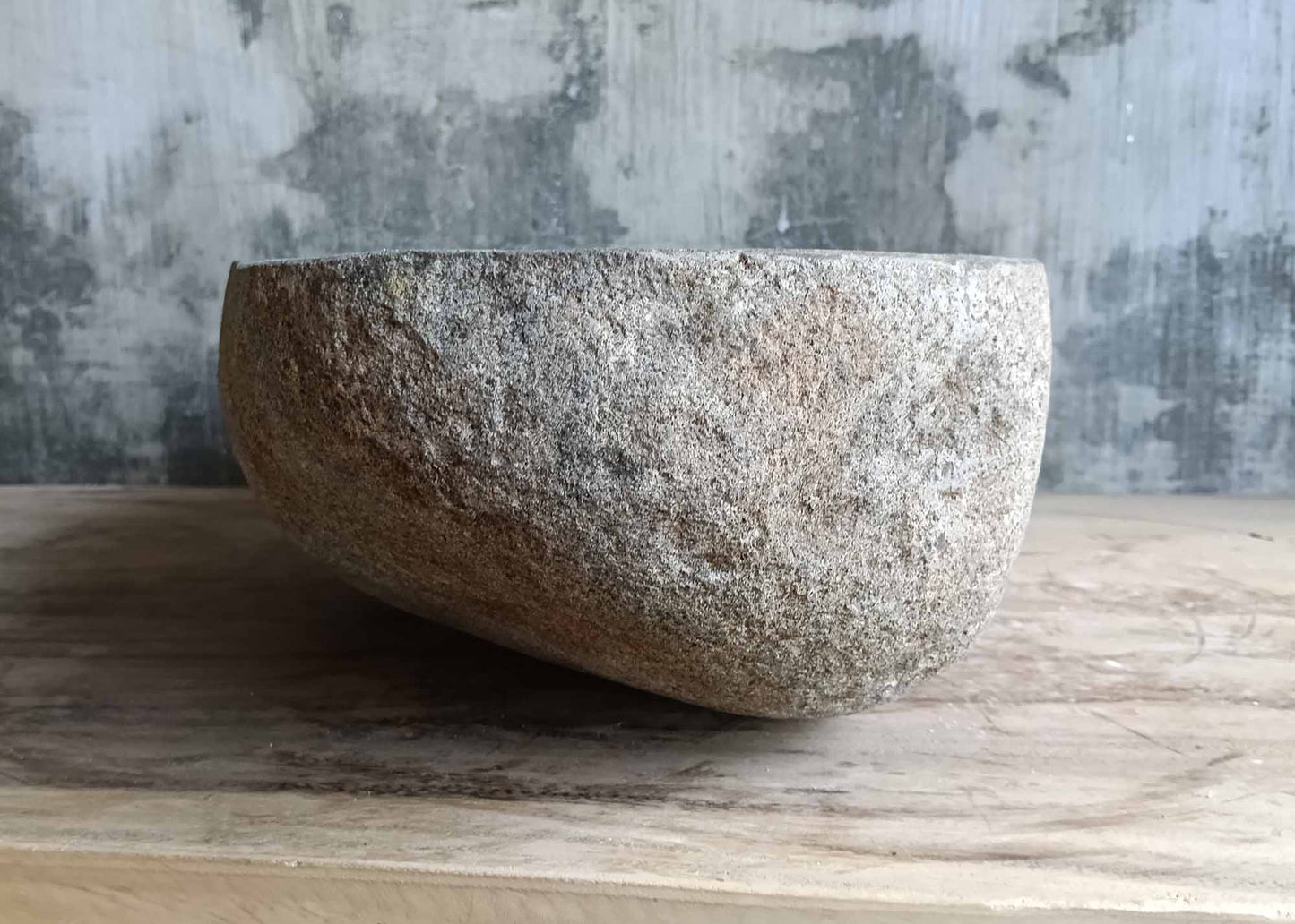 Left side of gray river stone sink with natural outer surface
