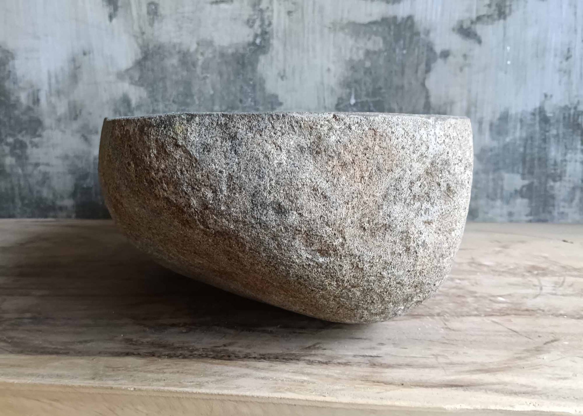 Left side of gray river stone sink with natural outer surface
