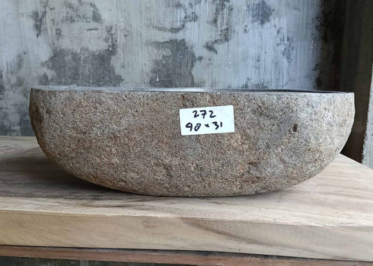 Front angle of handcrafted gray stone sink with widening pear contour
