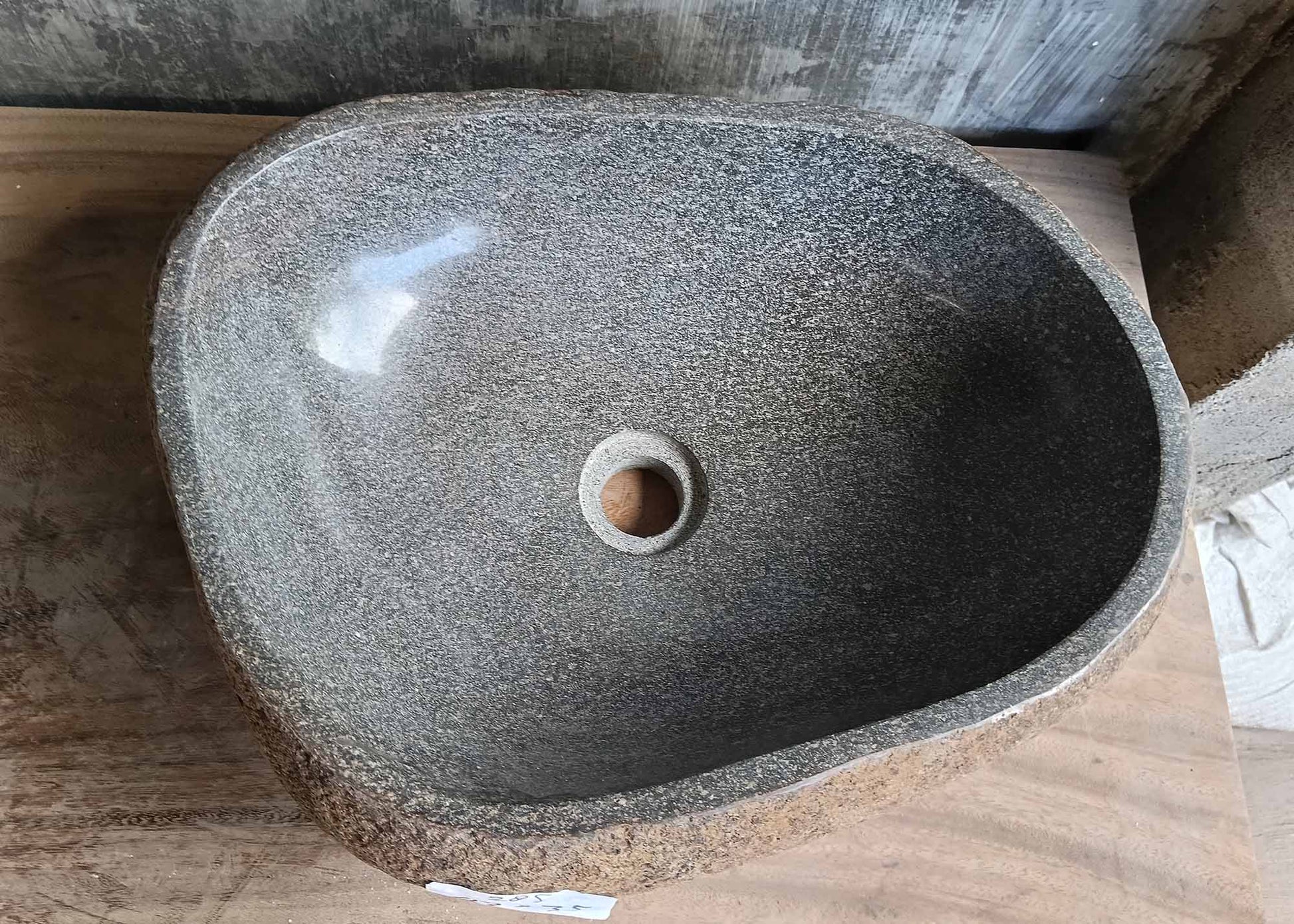 Top view of gray handcrafted river stone sink with four-sided irregular shape
