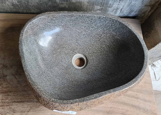 Top view of gray handcrafted river stone sink with four-sided irregular shape
