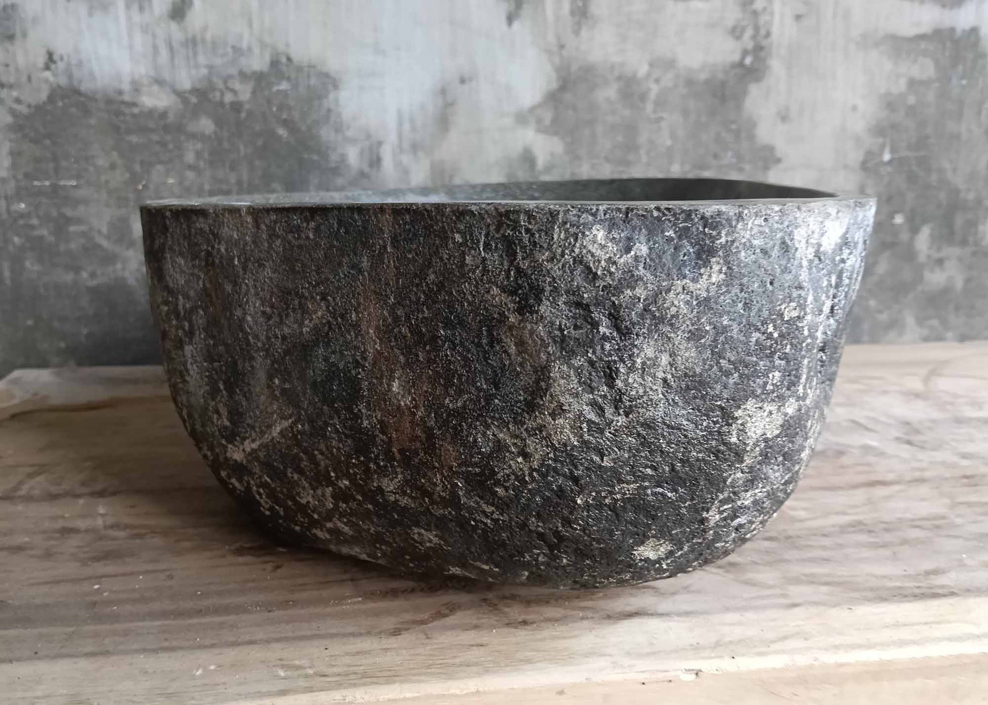 Left side of dark handcrafted river stone sink
