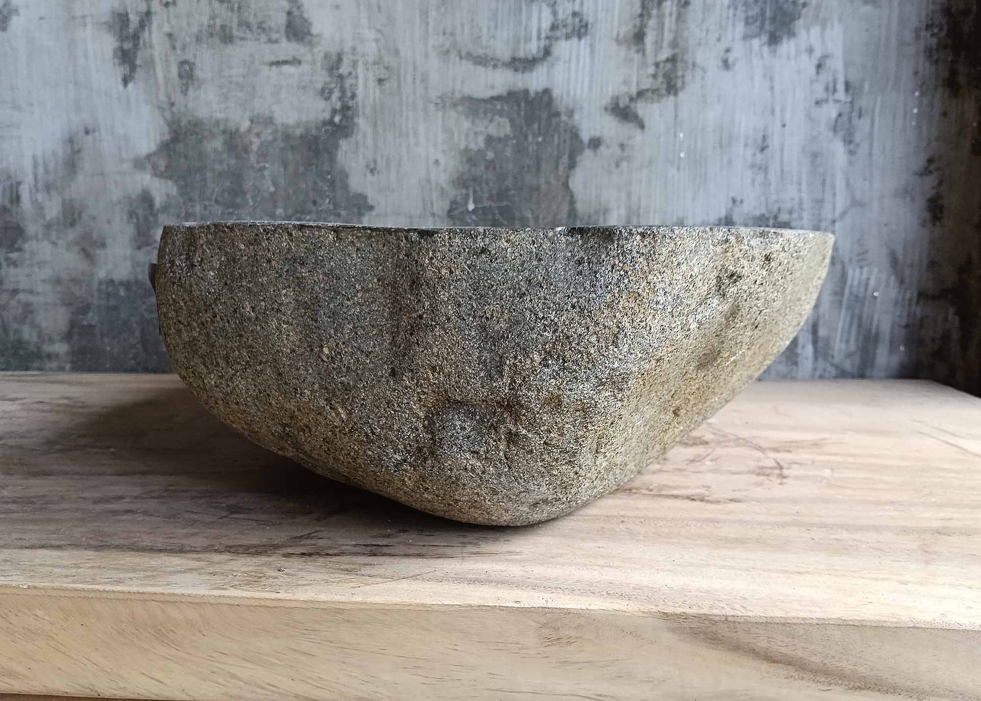 Left side of handcrafted river stone sink with raw edges
