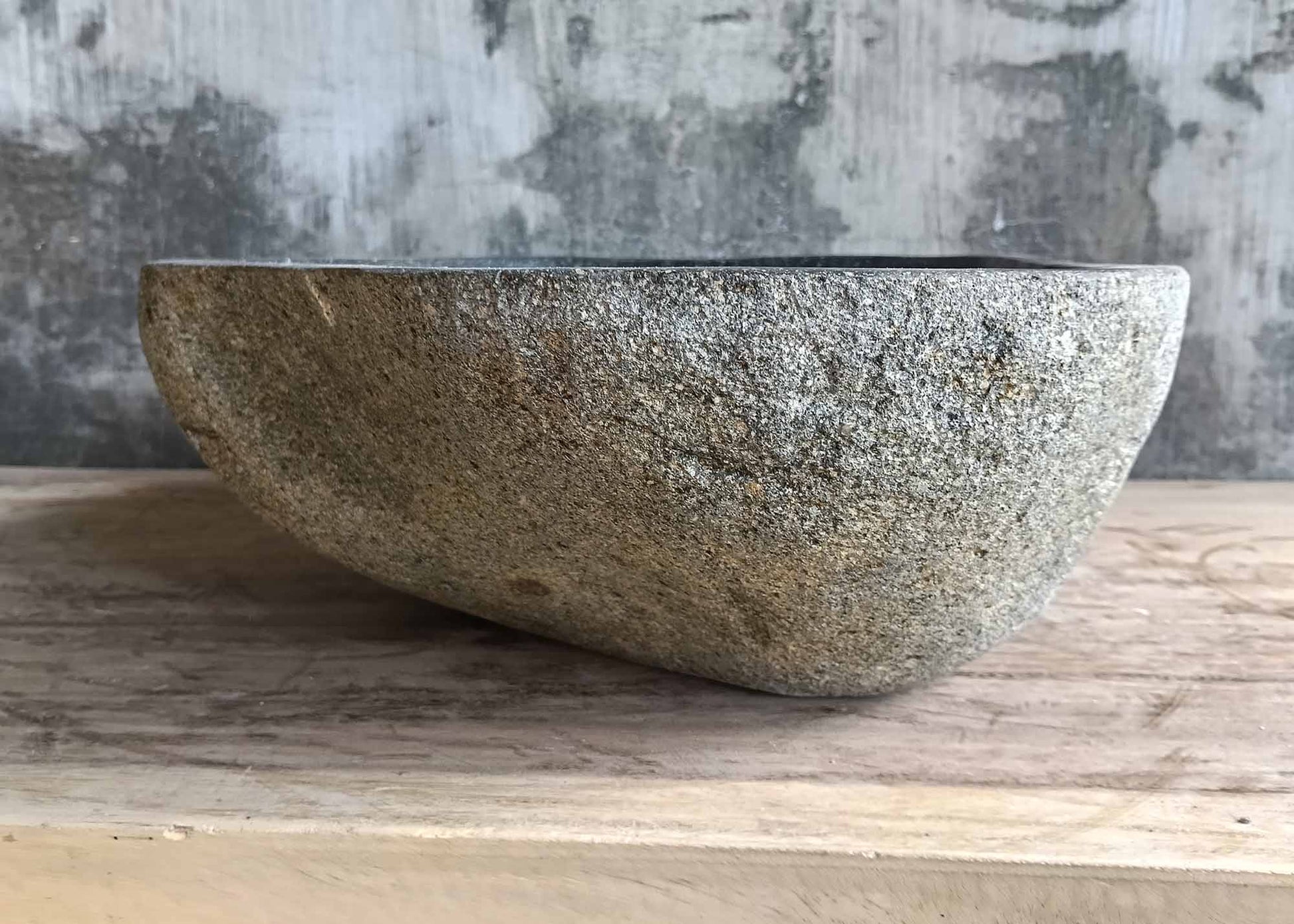 Back side of dark natural stone sink with organic form
