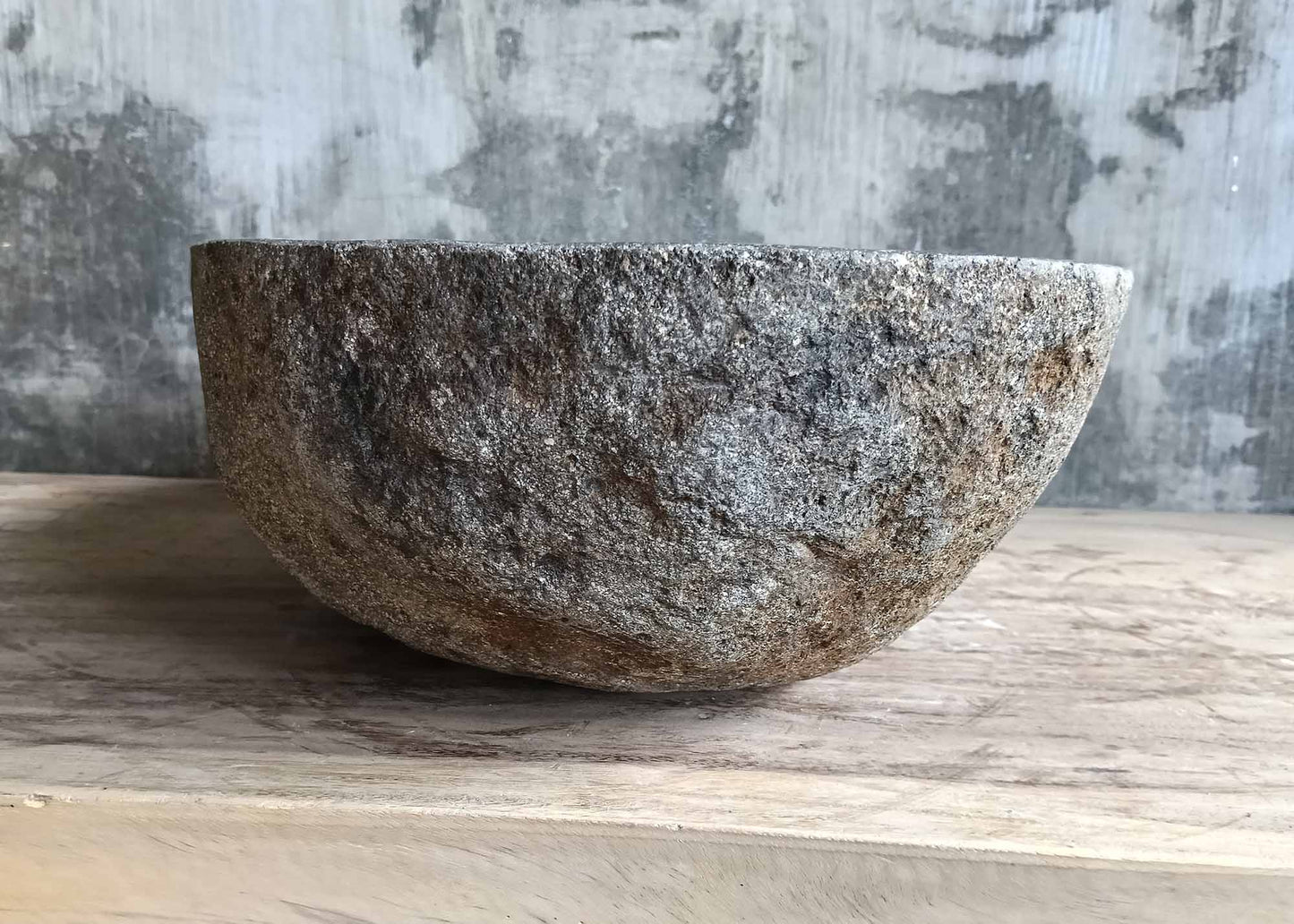 Back side of handcrafted sink 6297-5338 with rough stone texture and curved silhouette
