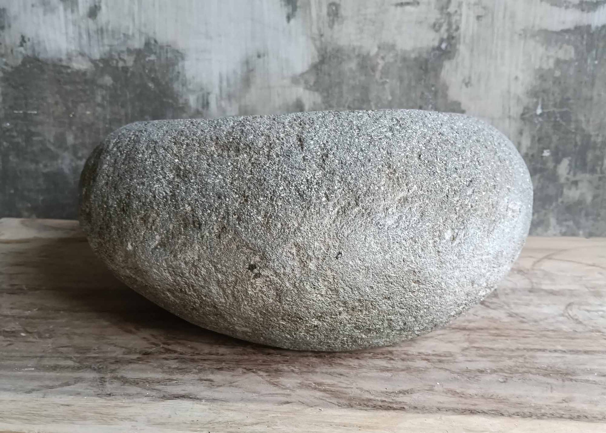 Back angle of polished gray oval river stone sink
