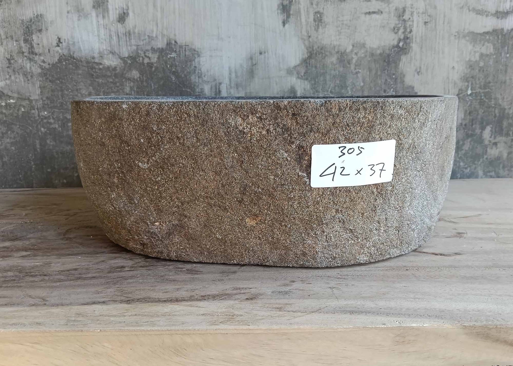 Right side view of irregularly shaped gray river stone sink
