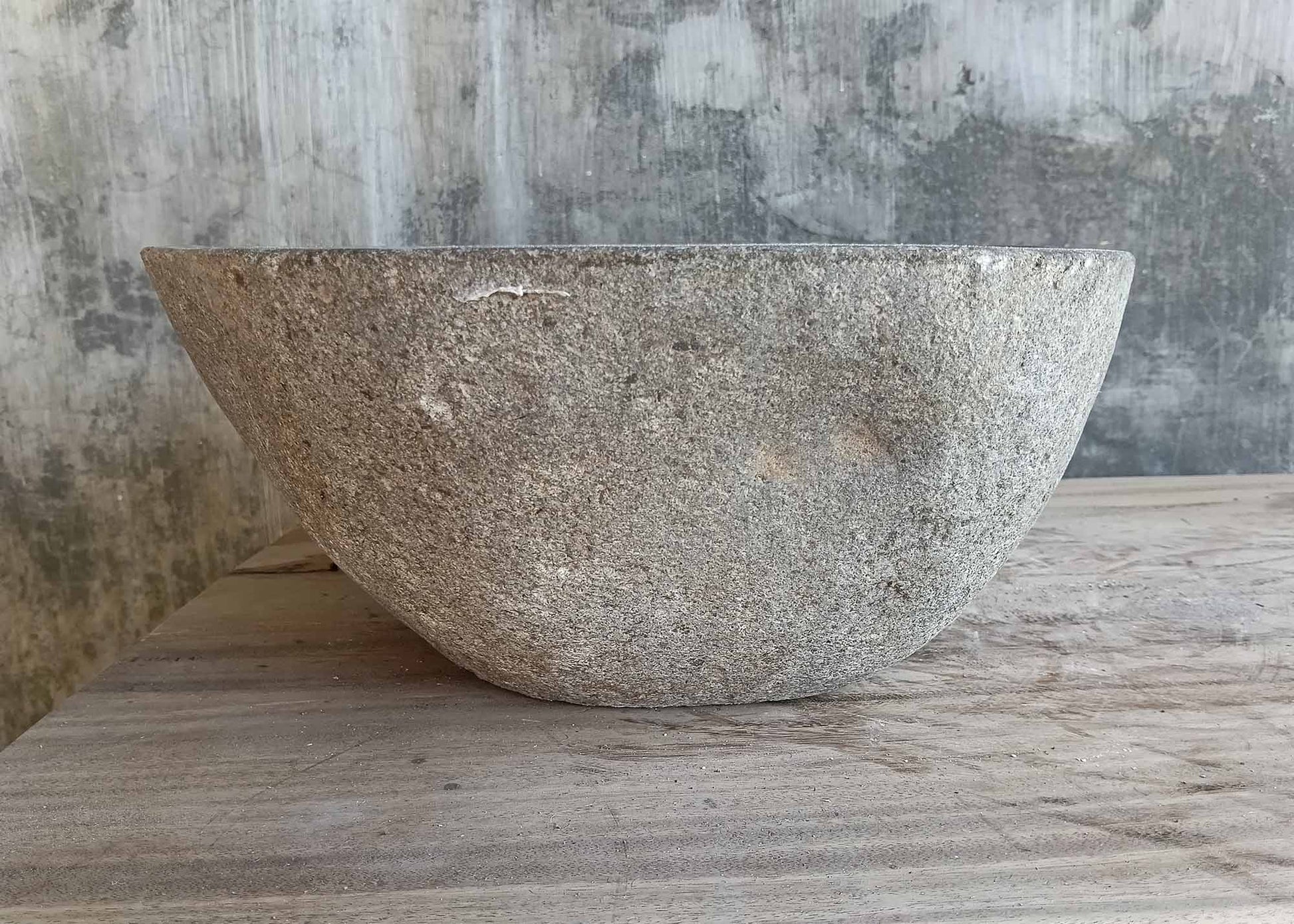 Left angle of handcrafted cylindrical gray stone basin
