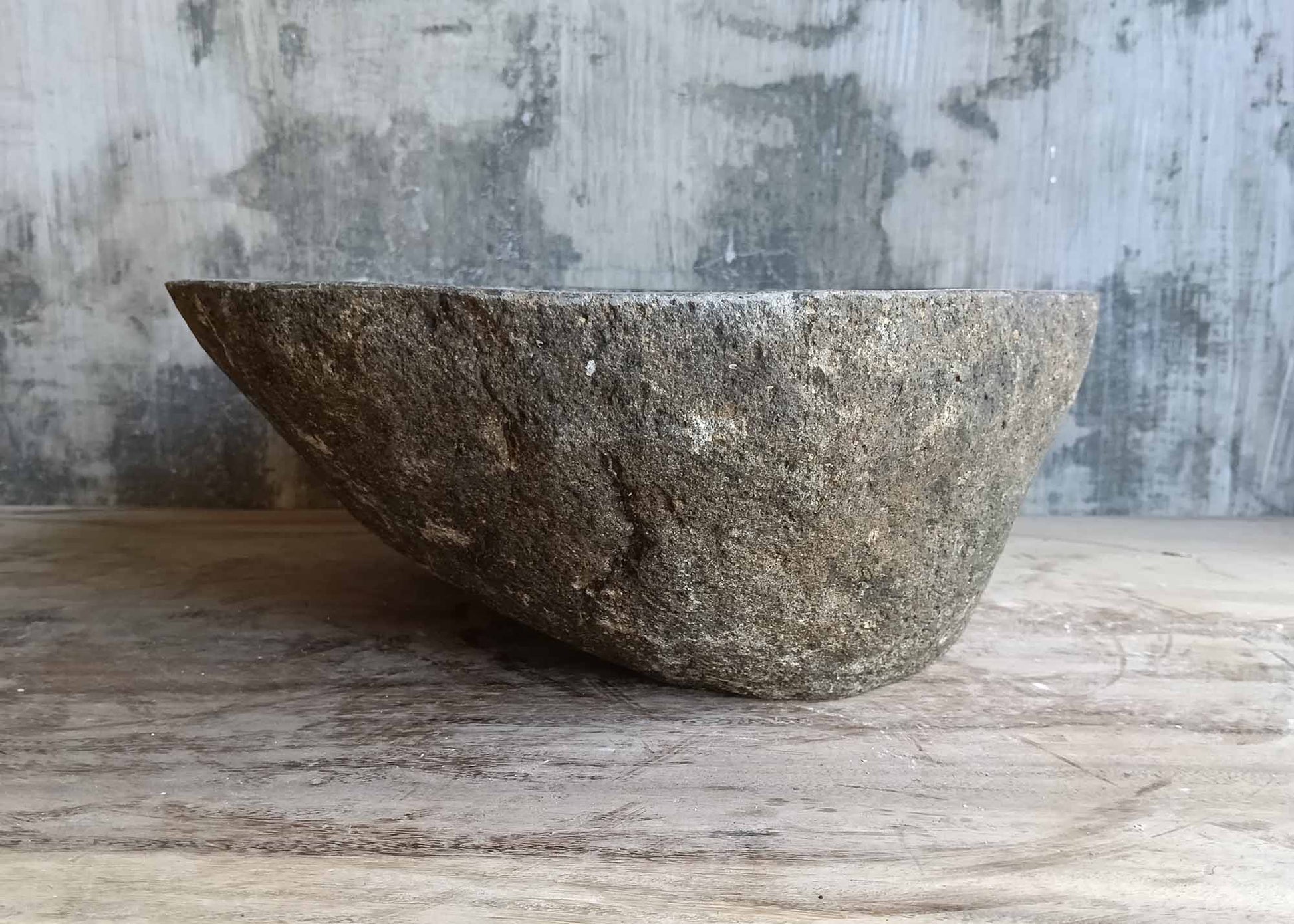 Right angle of striped brown-gray river stone sink with polished bowl
