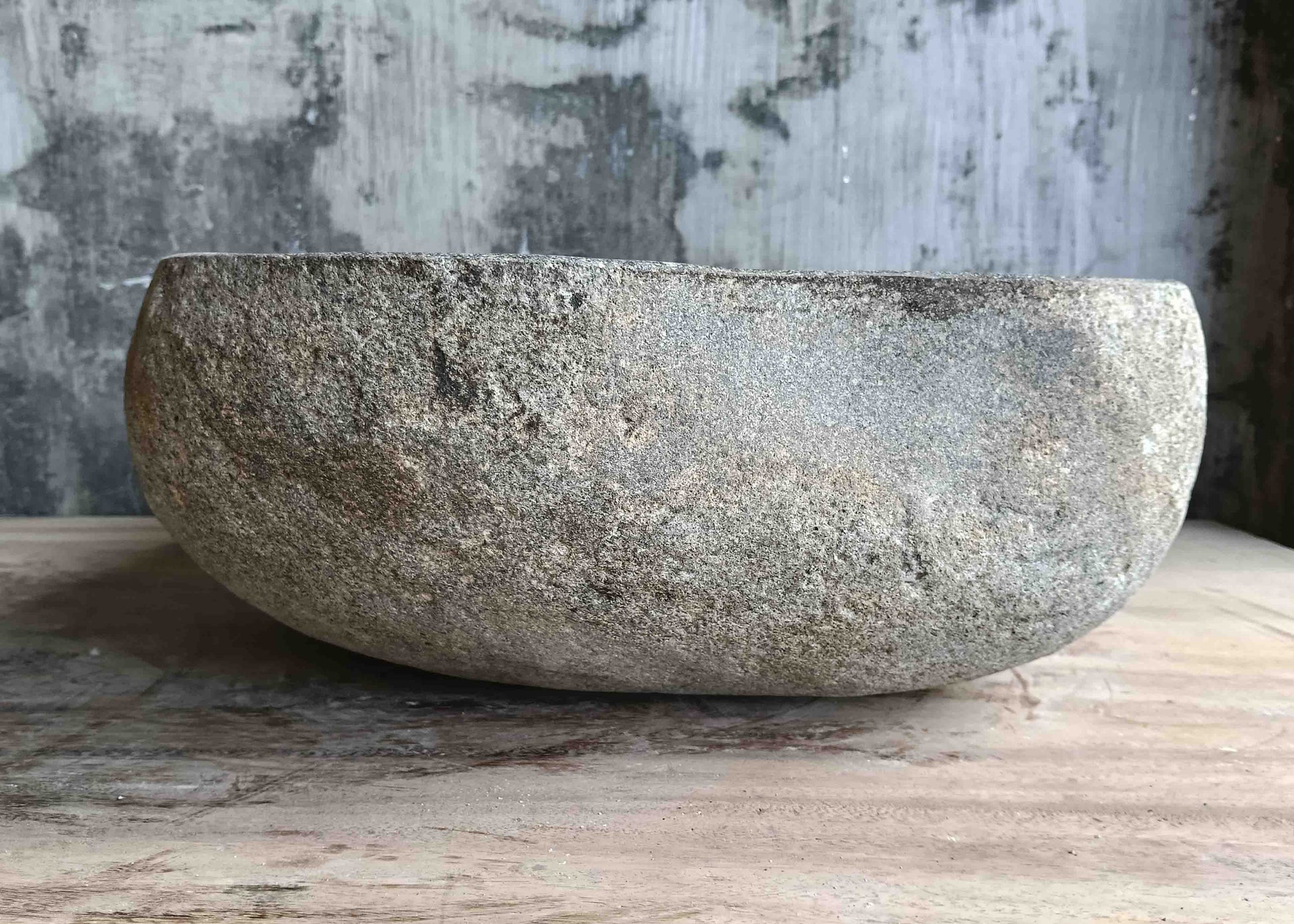 Left side view of 15×15 inch river stone sink installed in countertop, showing raw exterior texture
